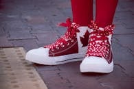 Closeup Photo of Person Wearing White-and-red Maple Leaf-printed Lace-up Sneakers